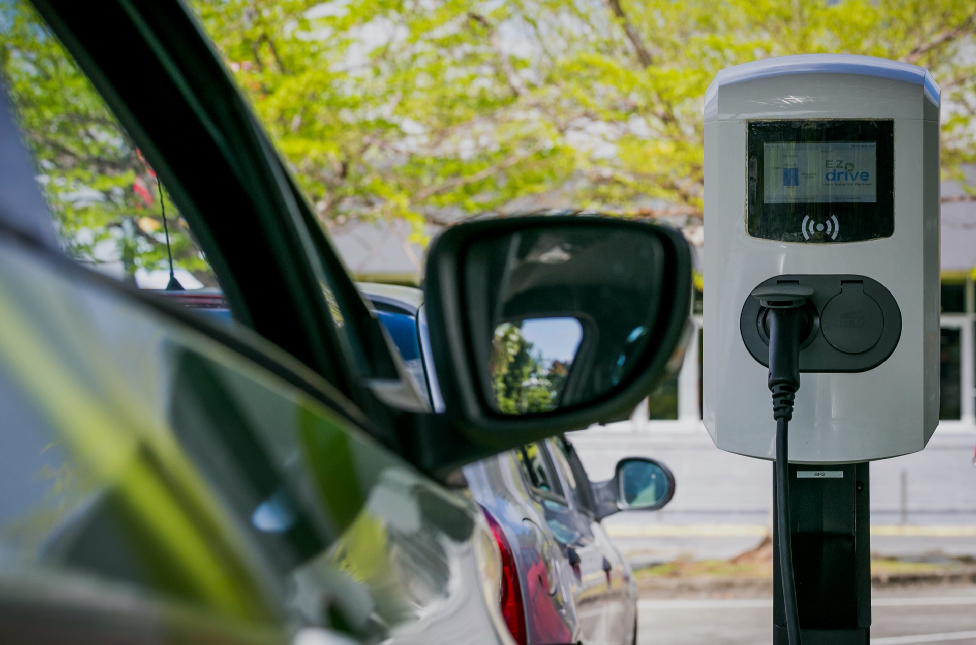 Borne de recharge EZdrive et véhicule électrique vus depuis le rétroviseur, photo prise par notre équipe en Outre-mer